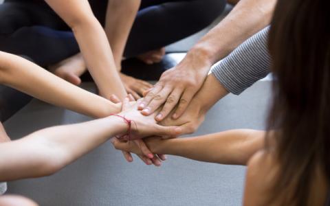 ragazzi che mettono le mani una sopra l'altra