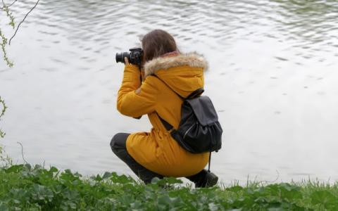 ragazza che fotografa un lago