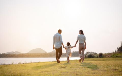 genitori che prendono per mano la figlia