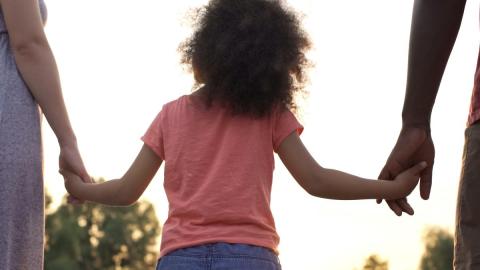 bambina di spalle tenuta per mano