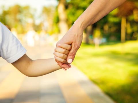 donna che tiene per mano un bambino