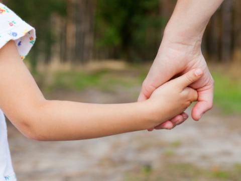 genitore che prende per mano la figlia