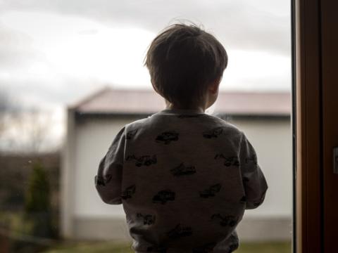 bambino di spalle davanti a una finestra