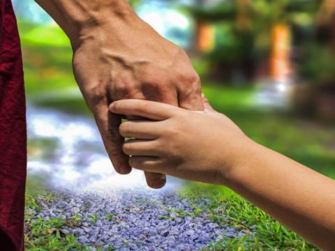 adulto che prende per mano un bambino