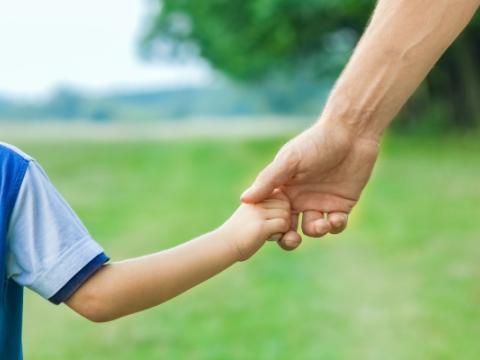 bambino e adulto che si tengono per mano